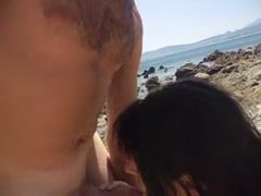 Bruneta suge pula pe plaja la nudisti