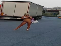 Blonda se plimba goala intr-o parcare de tiristi